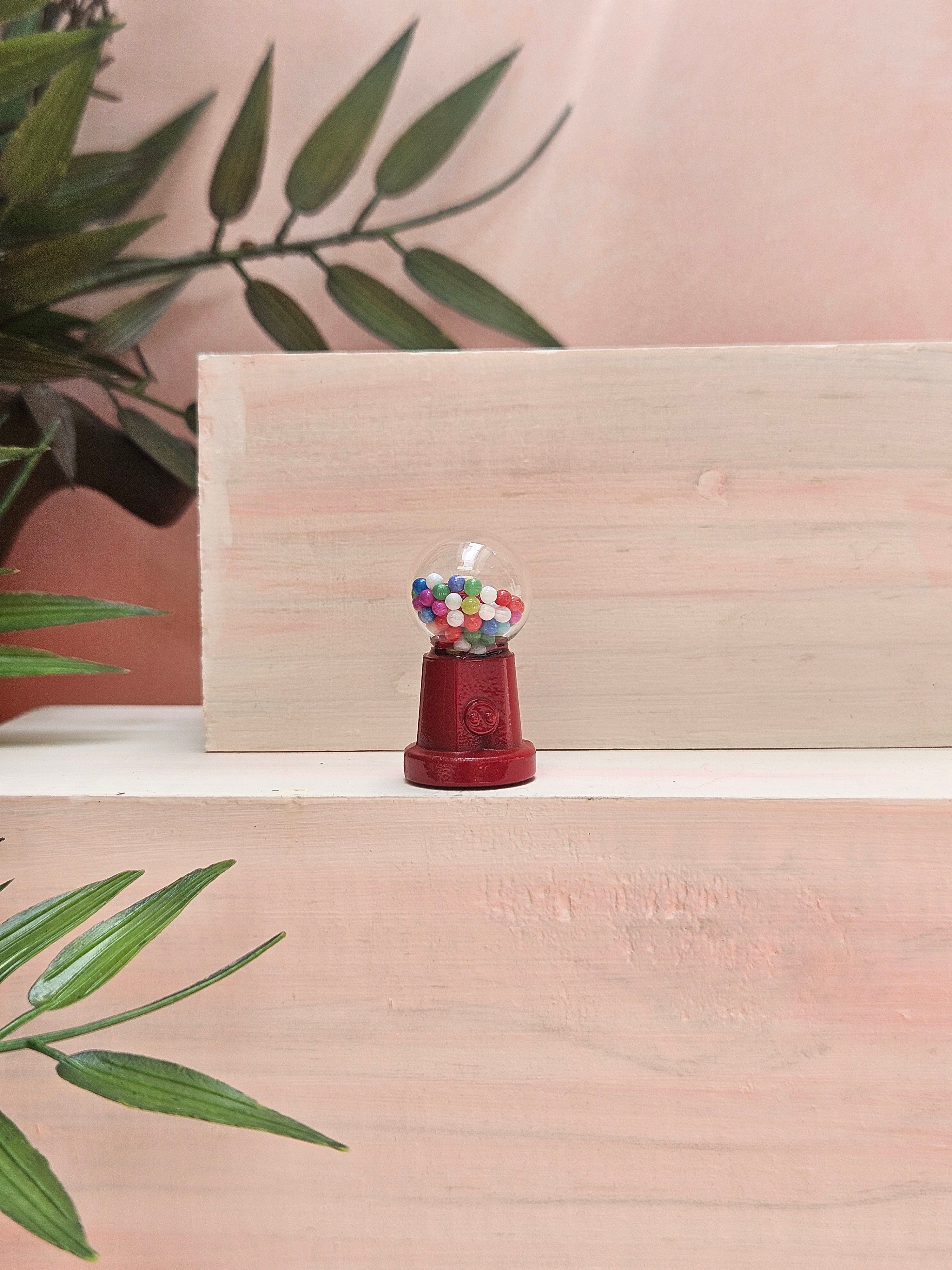 Miniature retro candy machine collectible with realistic dispenser design.