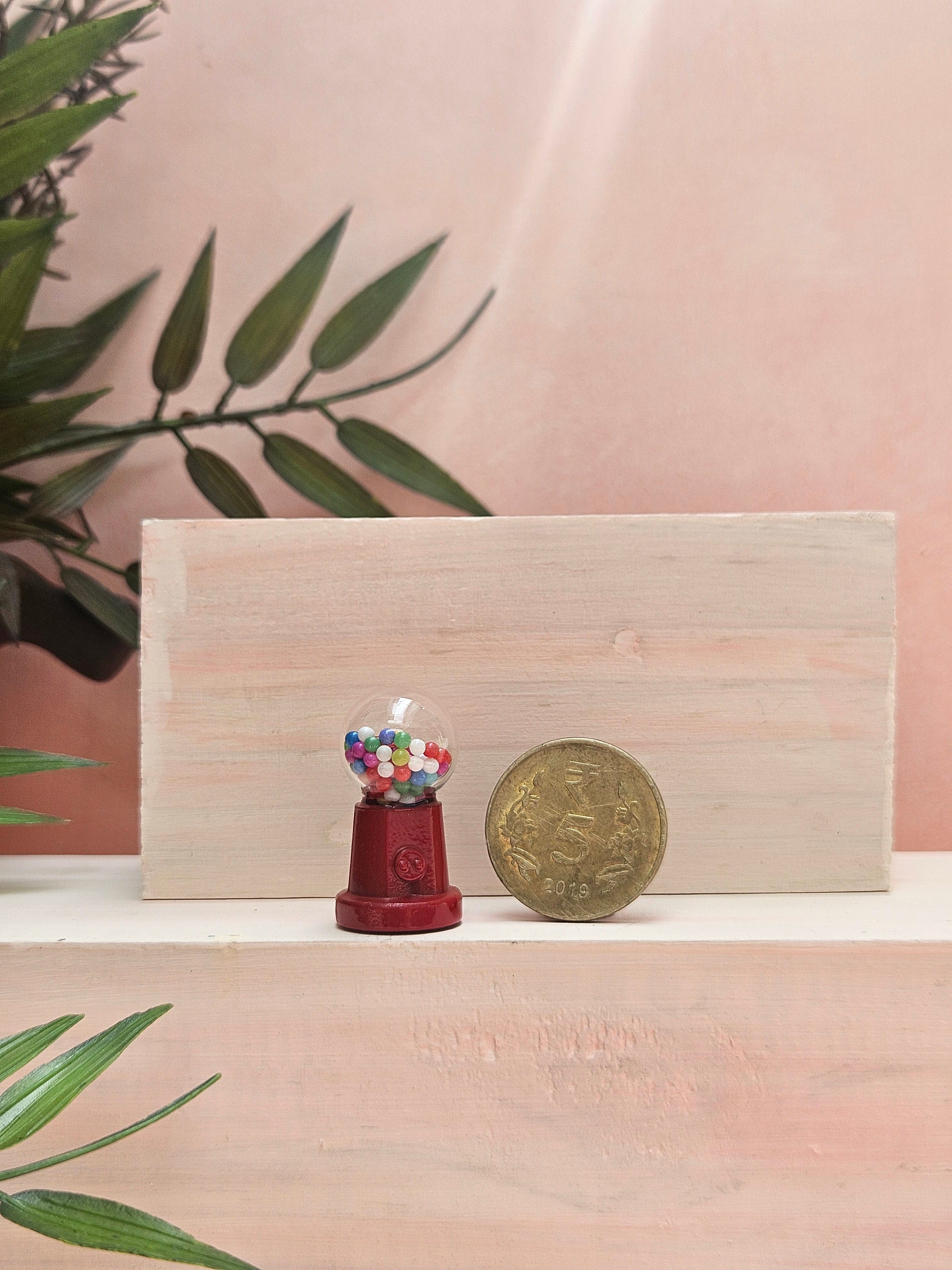 Miniature retro candy machine collectible with realistic dispenser design.