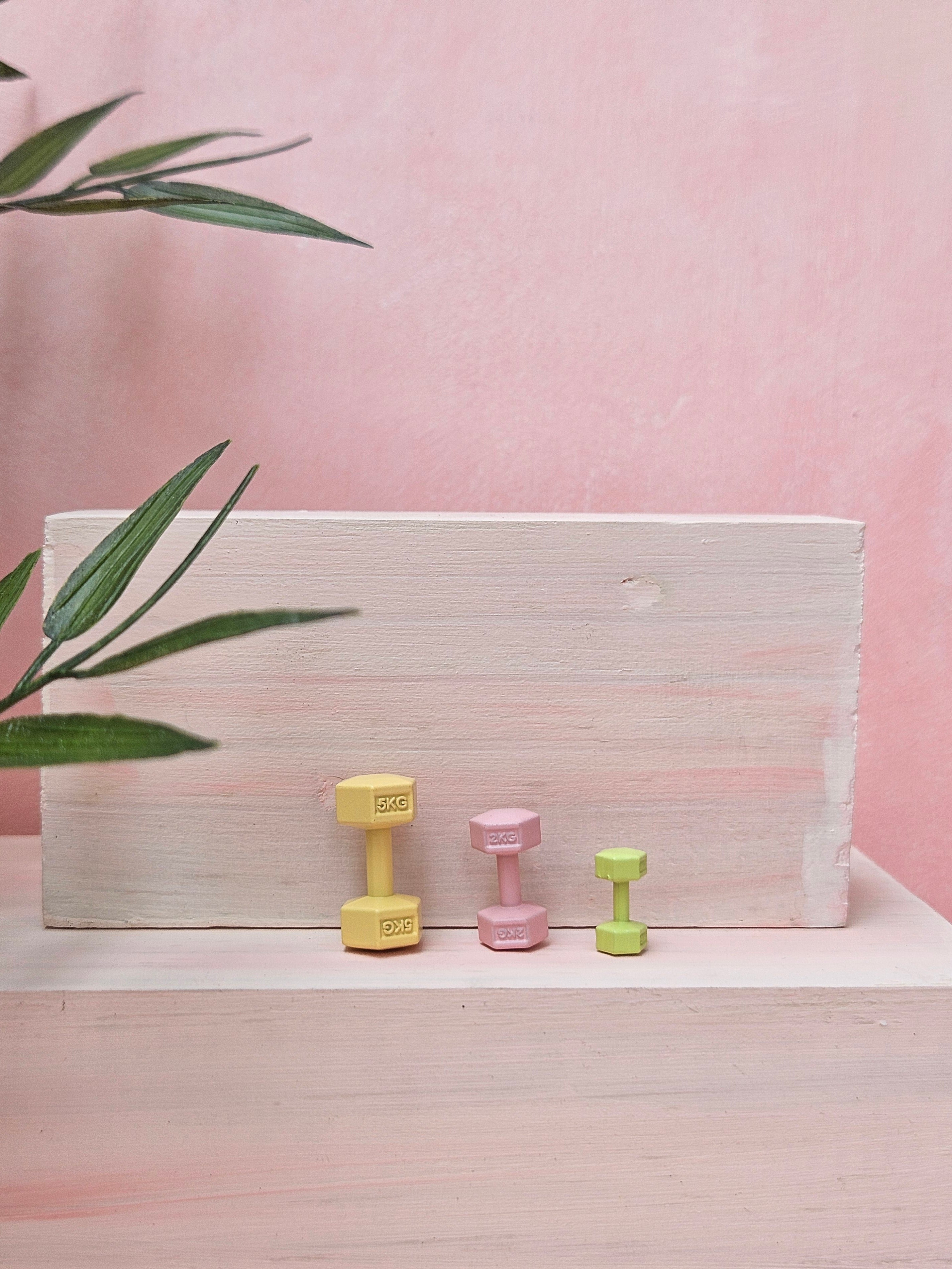 Miniature yellow dumbbells tiny gym props for dollhouse and craft projects in India.