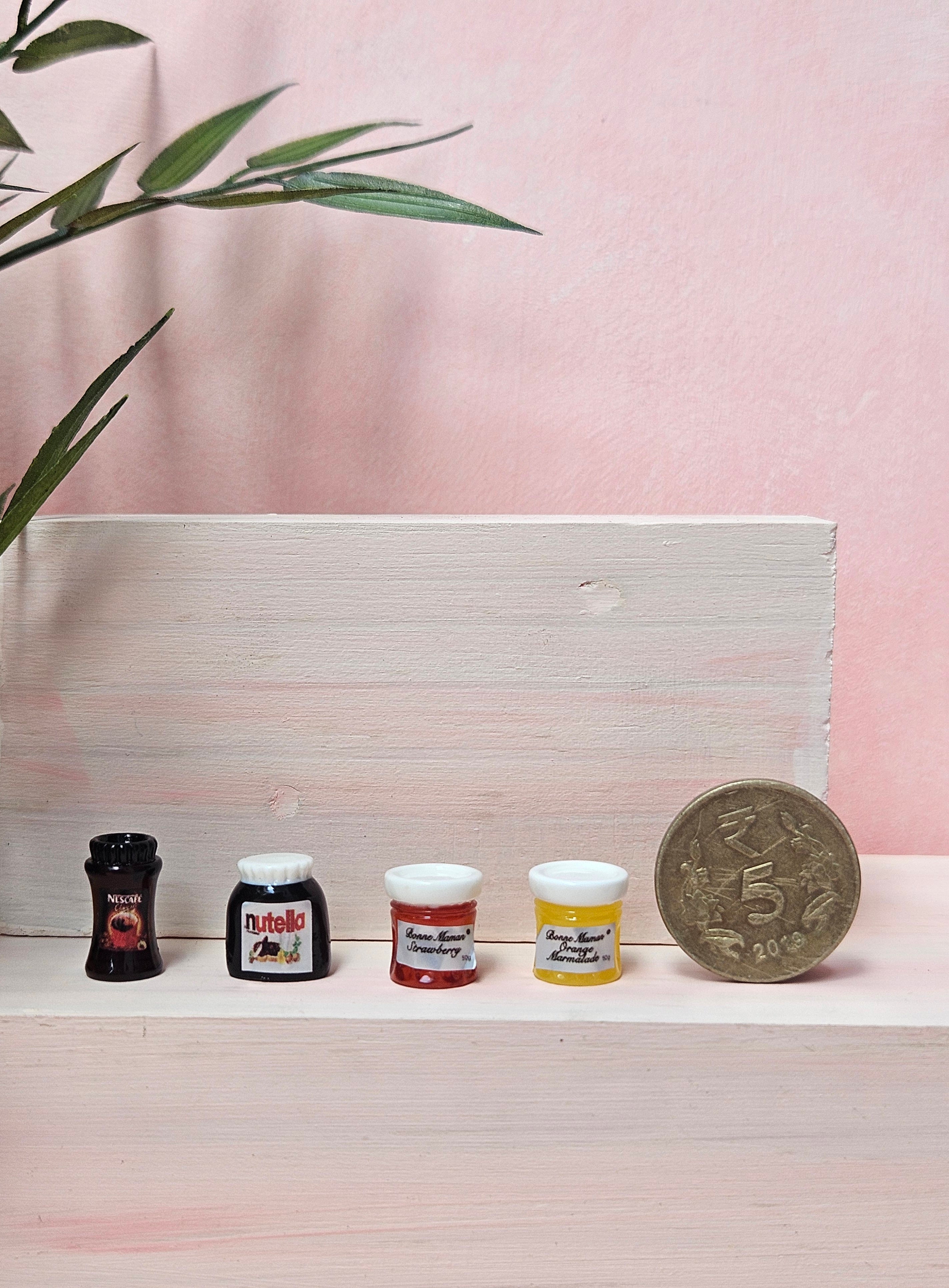 Miniature coffee, Nutella, and jam jars collectible craft props in India.